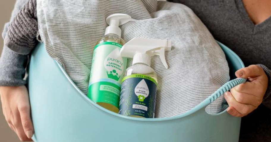 bottles of puracy laundry detergent and stain remover in basket of laundry