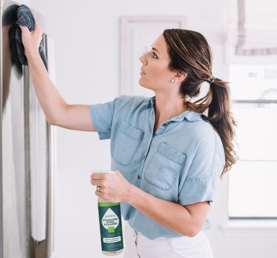 woman cleaning fridge doors with Puracy Stainless Steel Cleaner