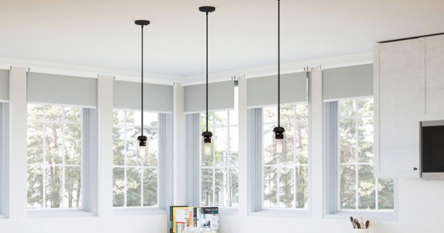 three black pendant lights with glass shades in kitchen