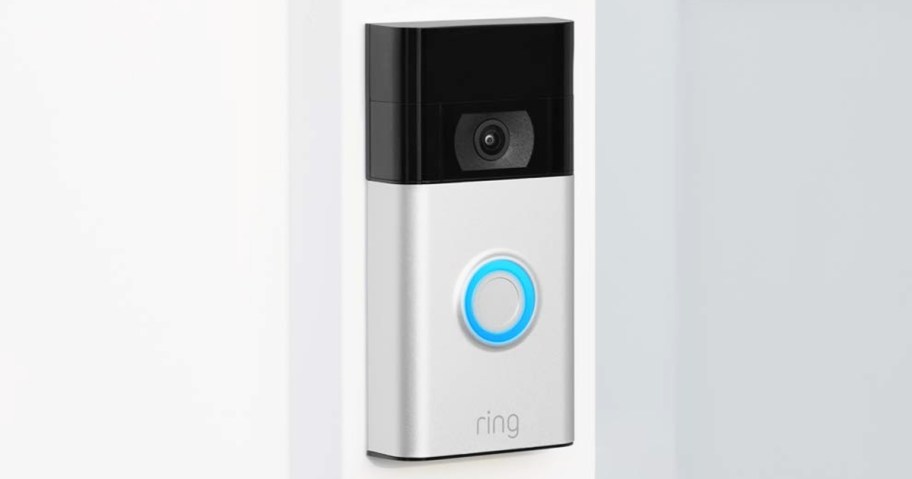 silver and black Ring Video Doorbell mounted on wall