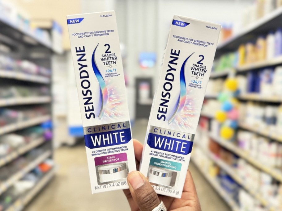 hand holding up two boxes of Sensodyne Clinical White Toothpaste