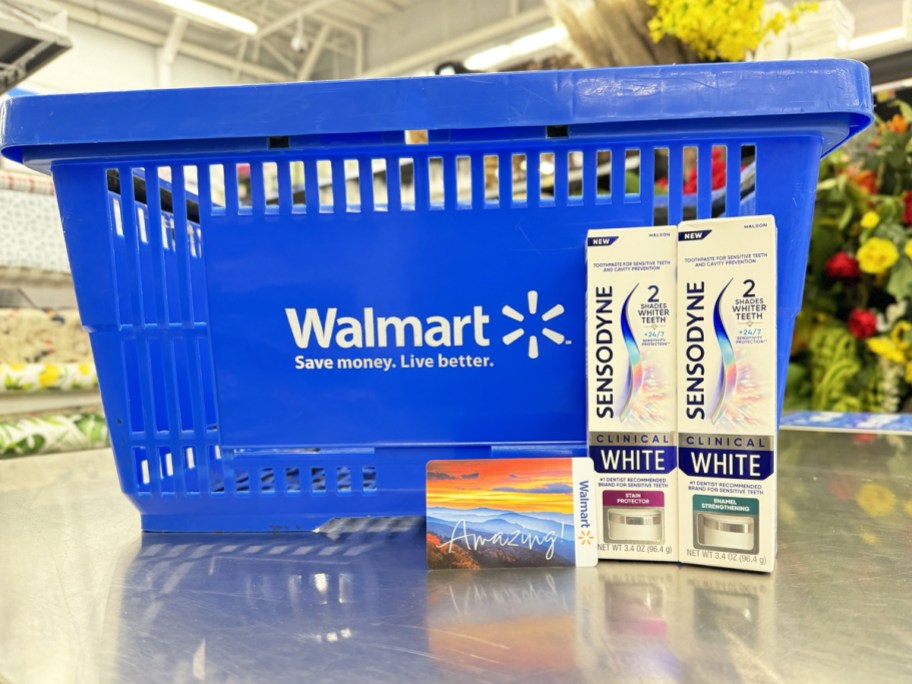 two boxes of Sensodyne Toothpaste & walmart gift card in front of blue walmart shopping basket