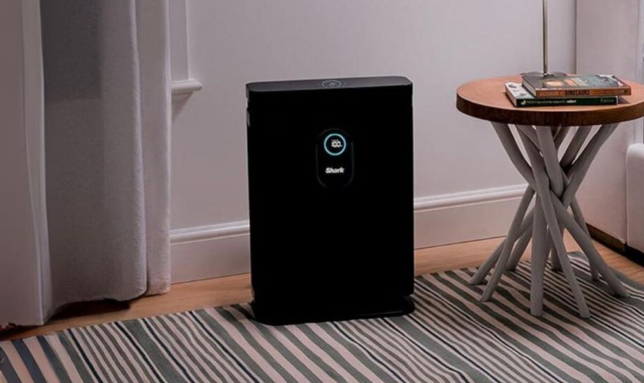 a shark air purifier in a room next to a side table