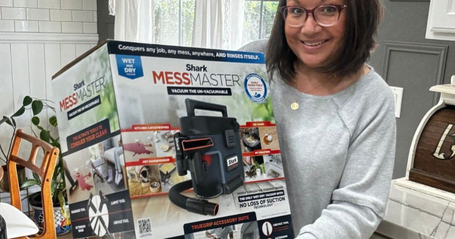 Woman holding a Shark MessMaster Wet Dry Vacuum brand new in the box
