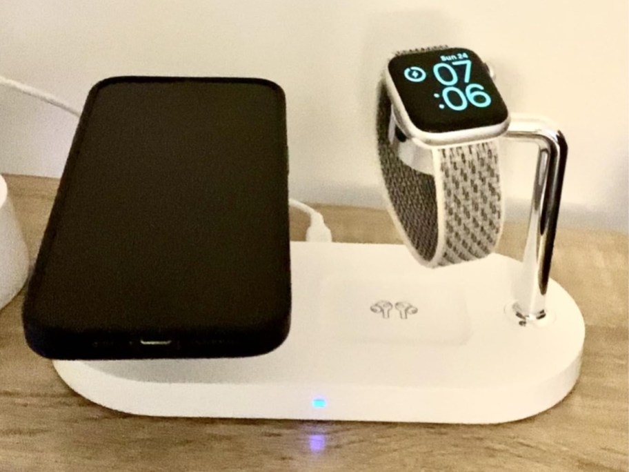 iphone and apple watch on a white and silver charging station