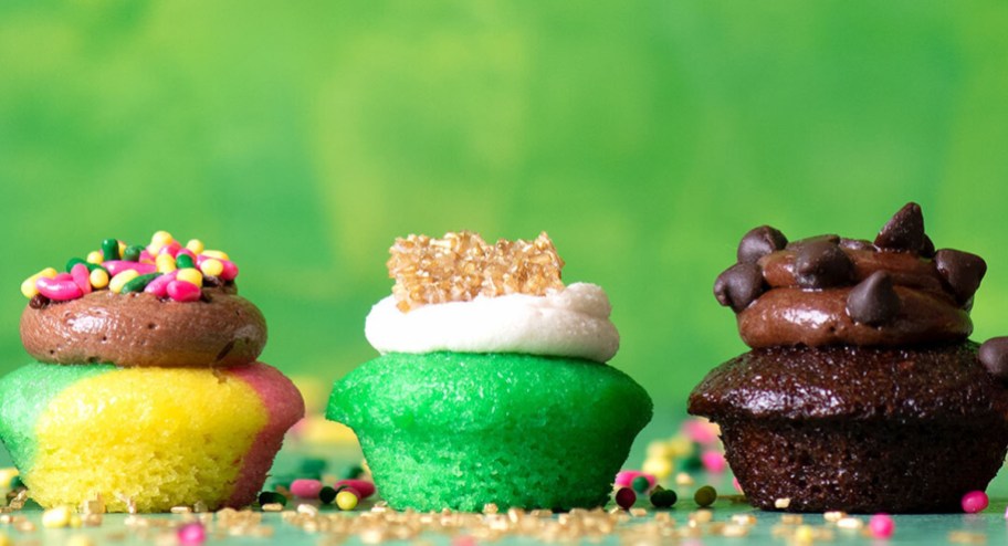 St. Patricks Day baked by Melissa cupcakes lined up with a green background