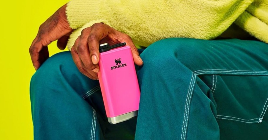 holding a neon pink stanley flask