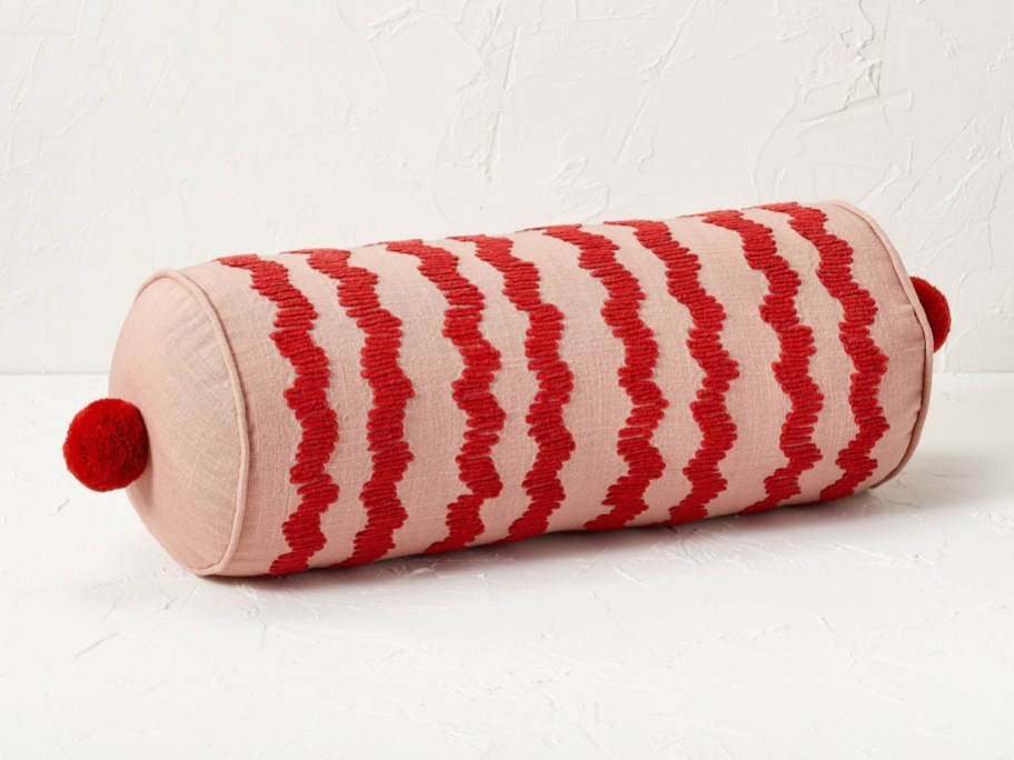 Stock image of bolster textured decorative pillow next to the wall