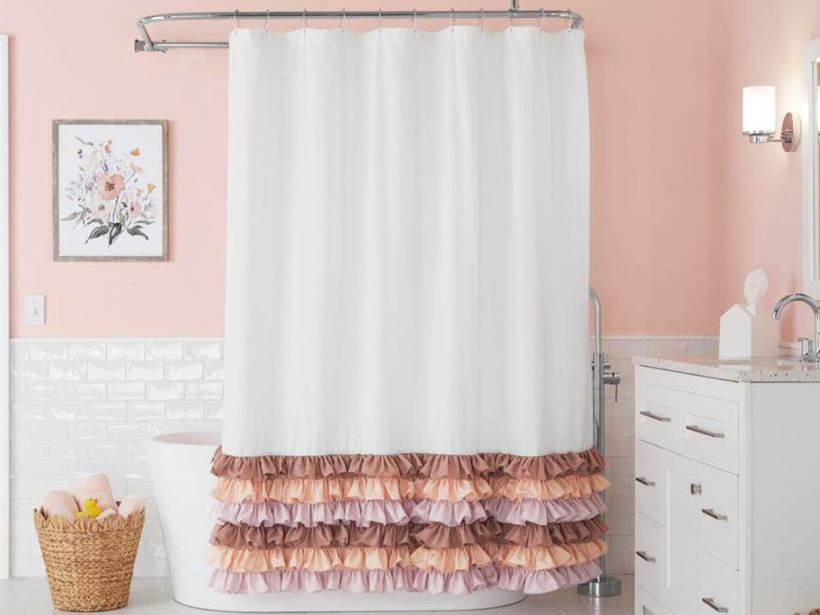 white shower curtain with pink ruffles at the bottom