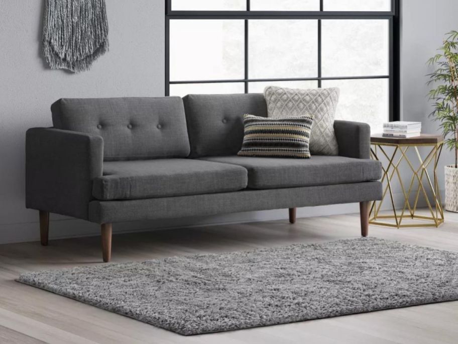 A gray shag rug set in front of a sofa