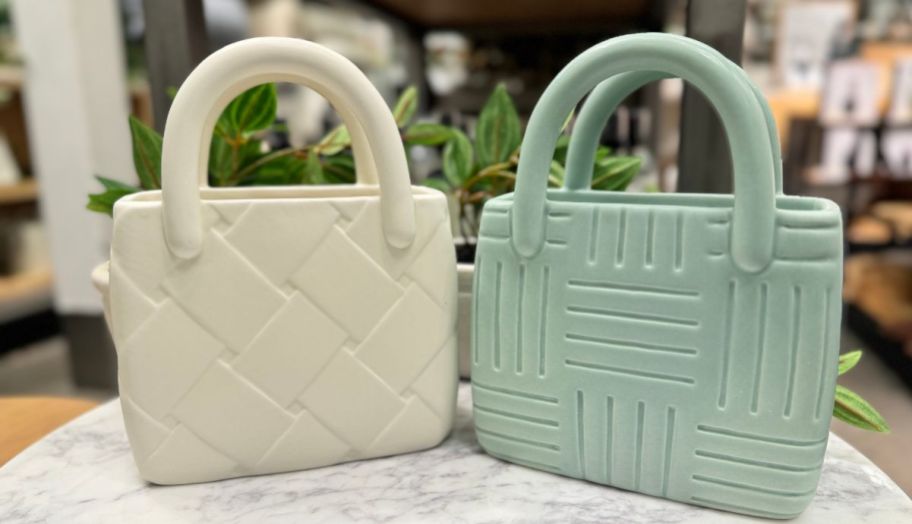 an ivory and a sage green handbag shaped flower vases
