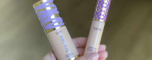 Hand holding tubes of Tarte Face Tape Foundation and Shape Tape Concealer