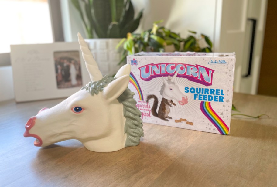a unicorn squirrel feeder next to the packaging