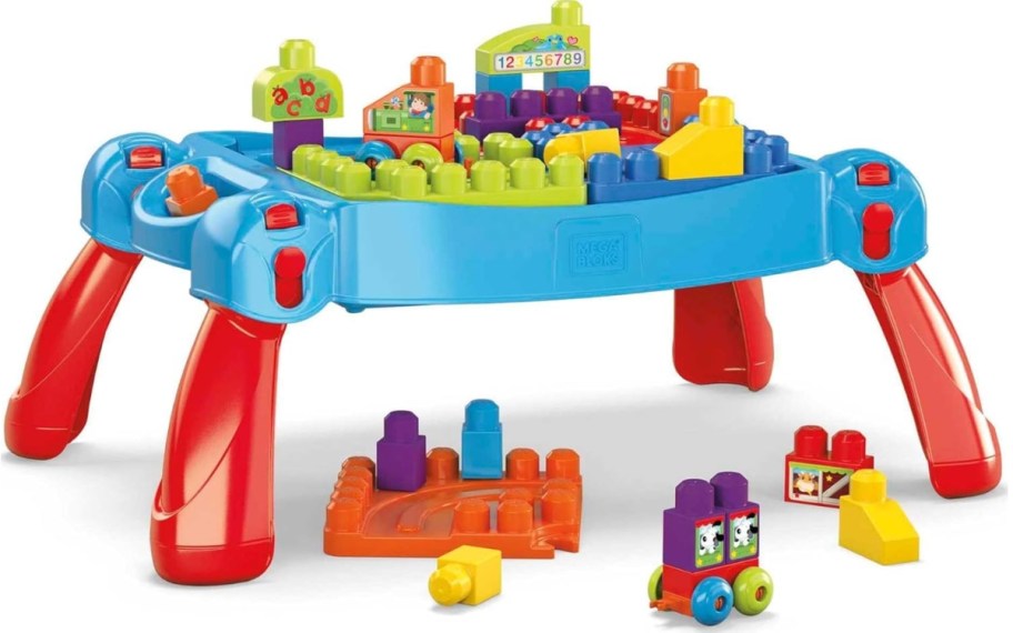 a MEGA BLOKS activity table with blocks and pieces on it and in front of it