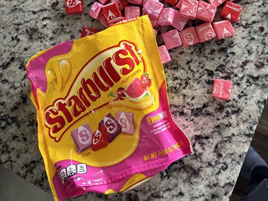 open bag of Starburst FaveREDS Fruit Chews with individual chews laying around it