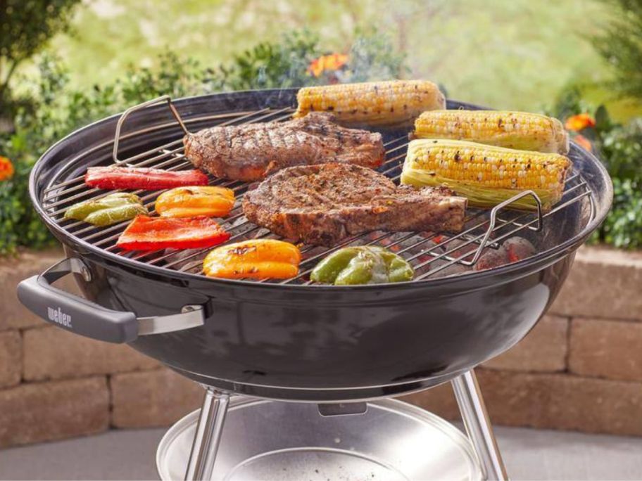 Weber Jumbo Joe Charcoal Grill with grilled meats and veggies cooking on it