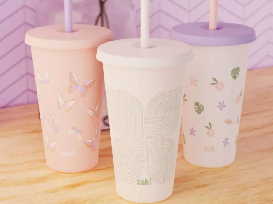 3 plastic tumblers with lids and straws