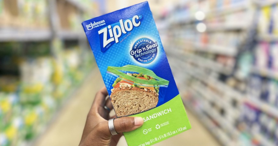 hand holding up a blue and green box of Ziploc Sandwich Bags