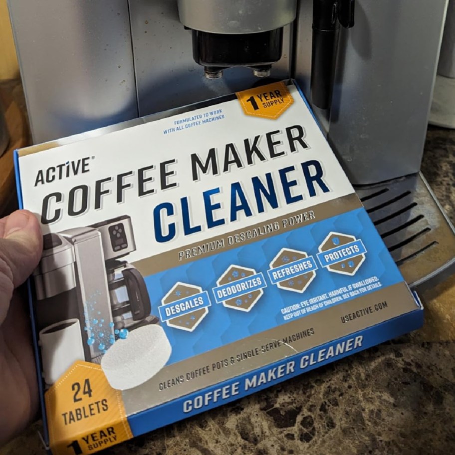 coffee maker cleaner pods in box next to coffee machine