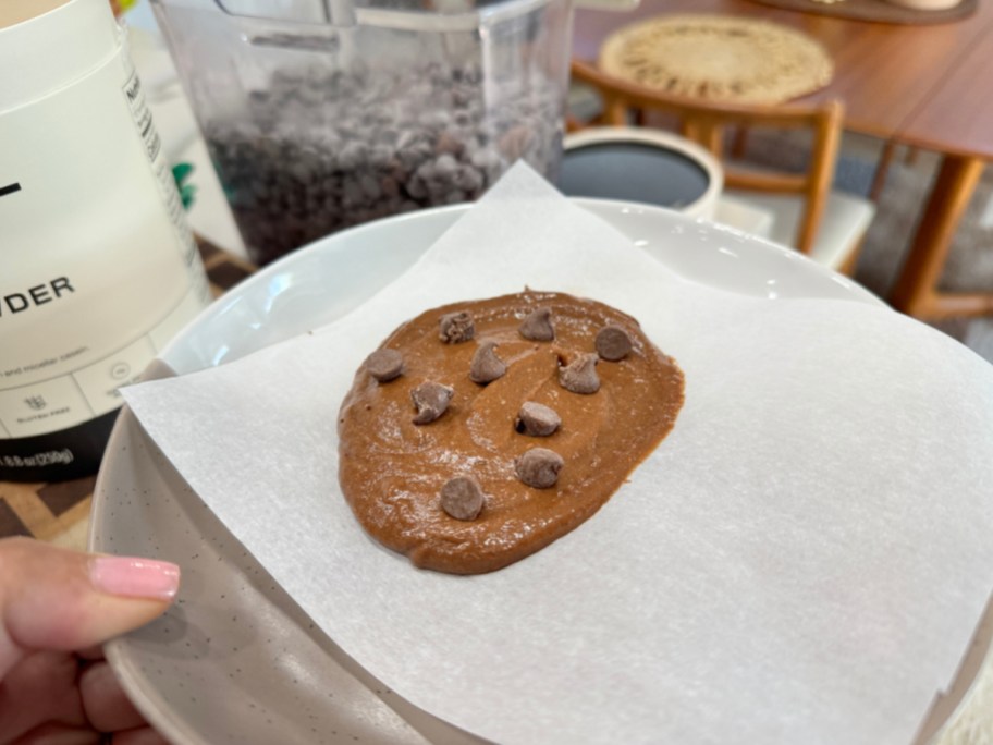 adding chocolate chips to a protein cookie