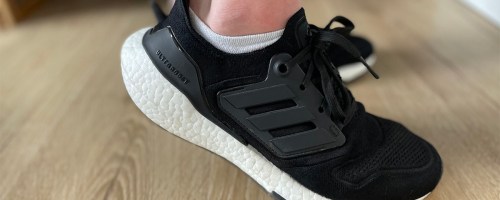 person wearing black and white adidas ultraboost shoes