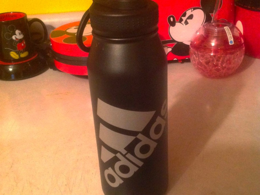 black adidas water bottle sitting on countertop with disney appliances in background