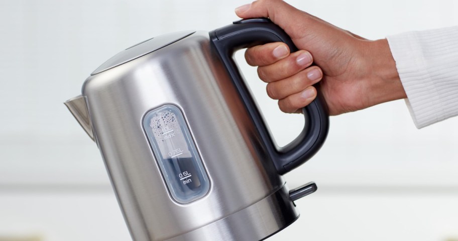 holding an electric kettle