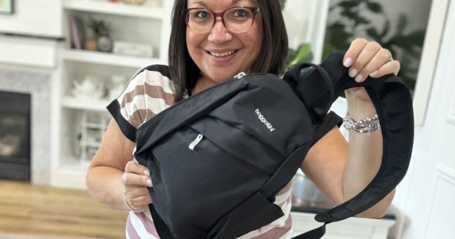 Woman holding a black Baggallini sling bag