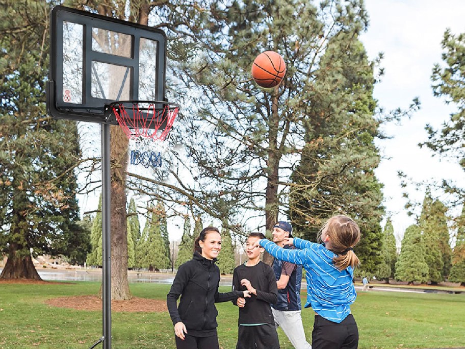  basketball hoop outside while kids and teens play together