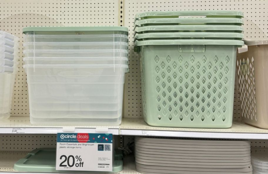 a clear storage bin next to a light green perforated bin on a store shelf
