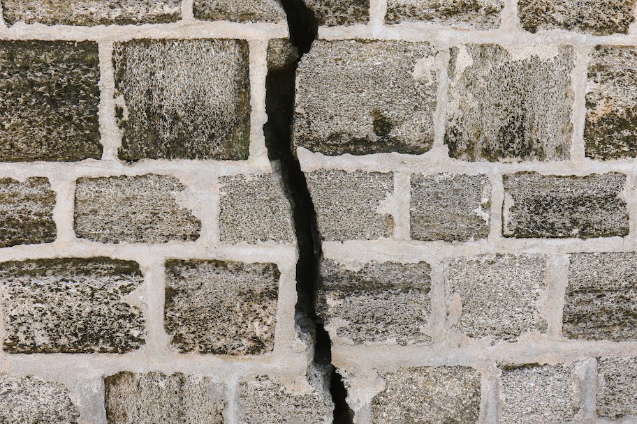 gray brick wall with crack down middle