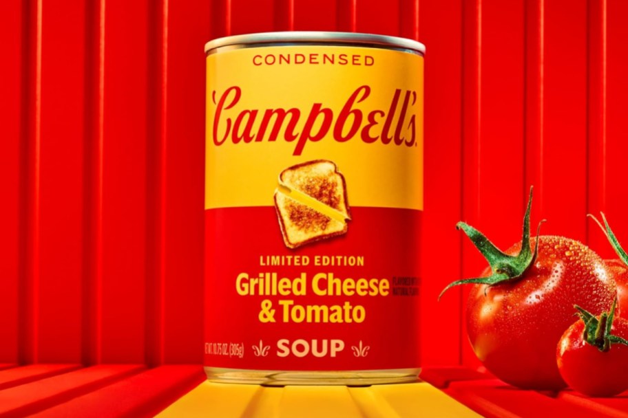 campbell's grilled cheese and tomato soup can against a red curtain background