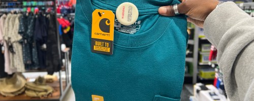 hand holding blue carhartt pocket tee