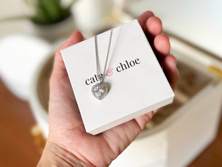 hand holding heart white gold necklace over box
