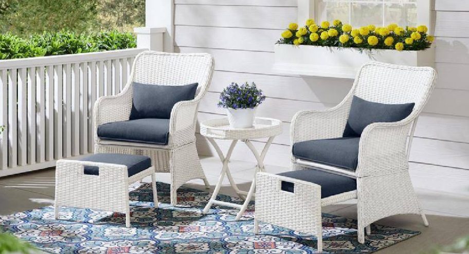 chair patio set with patterned rug underneath and flower behind