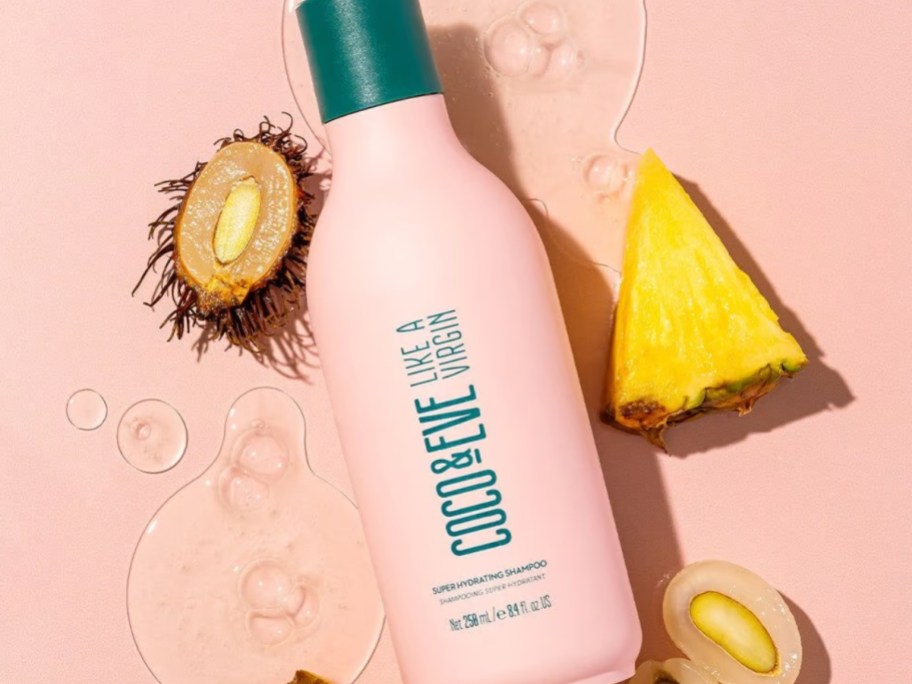 bottle of Coco & Eve Super Hydrating Shampoo surrounded by tropical fruits