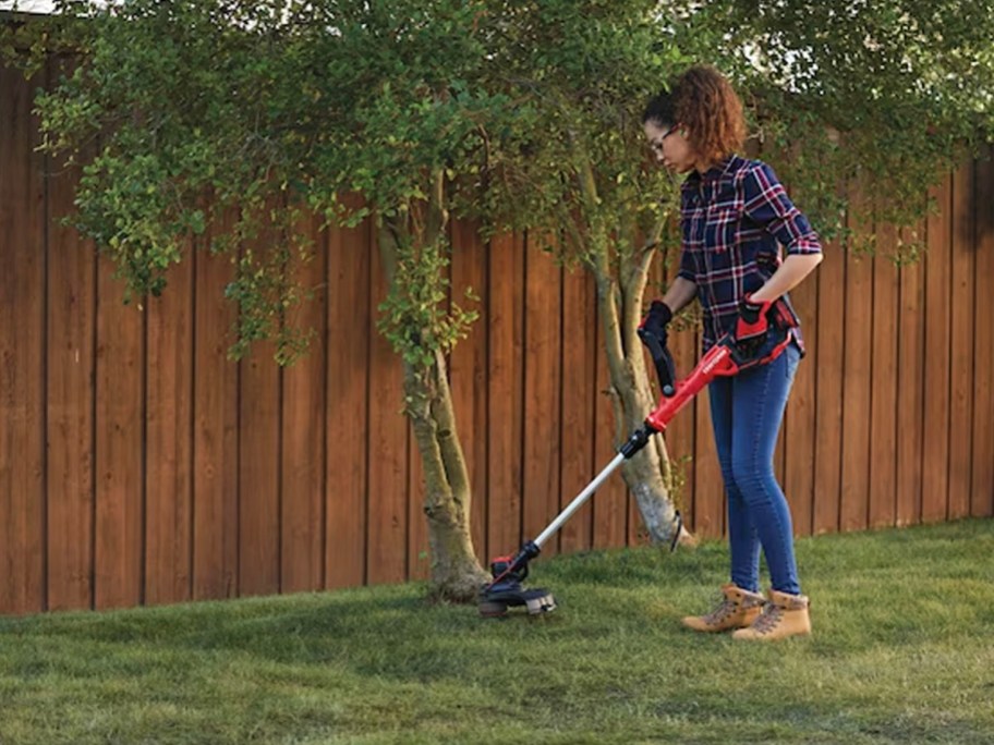 woman using red and black craftsman string trimmer