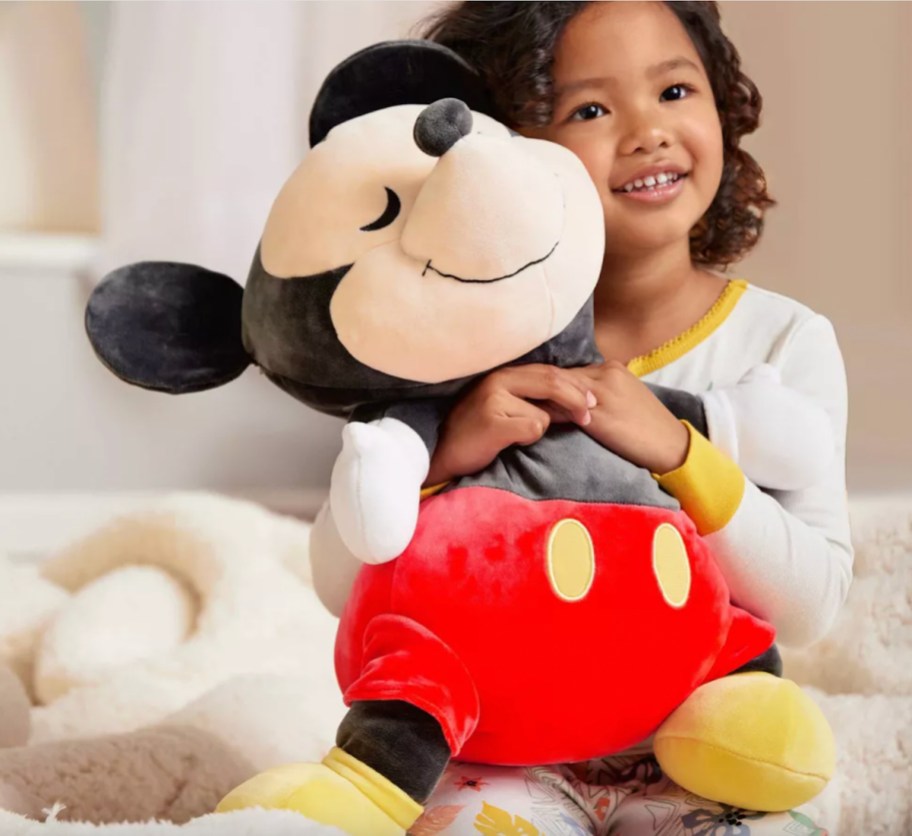 child holding large mickey mouse pillow plush
