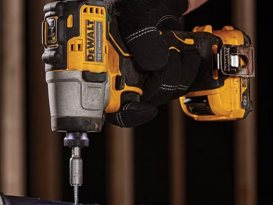 hand holding dewalt yellow and black impact driver