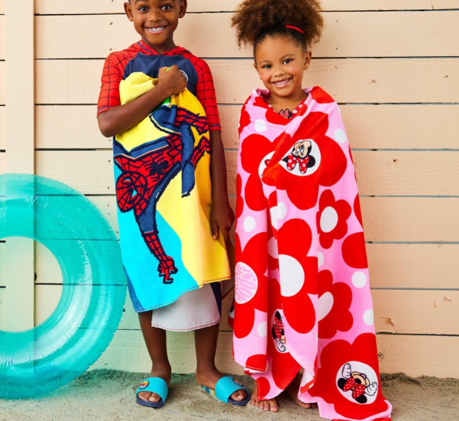two kids wrapped in disney towels