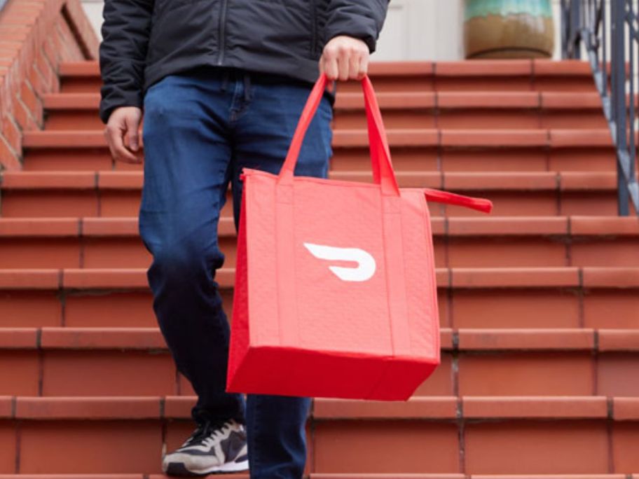 doordasher with doordash bag walking down the stairs