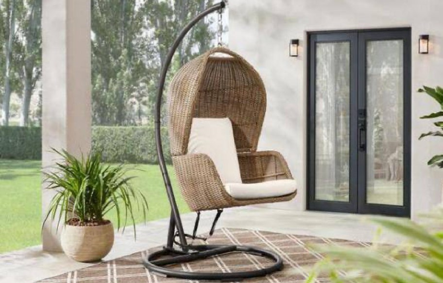 egg chair displayed in the patio with rug and plant