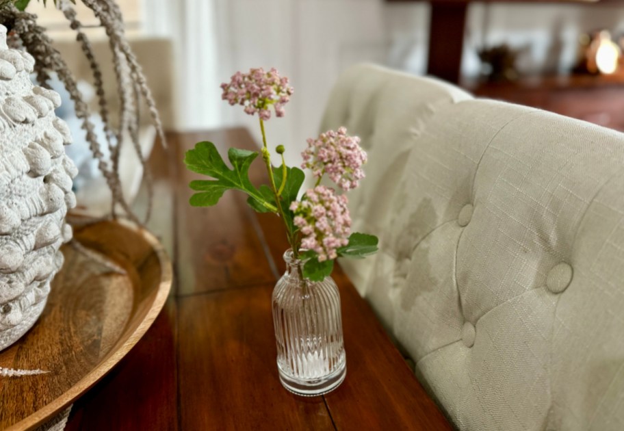 faux sedum floral arrangement in a glass vase displayed on a table