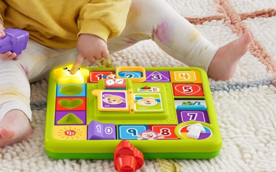 a baby playing with the fisher price puppy's game activity set