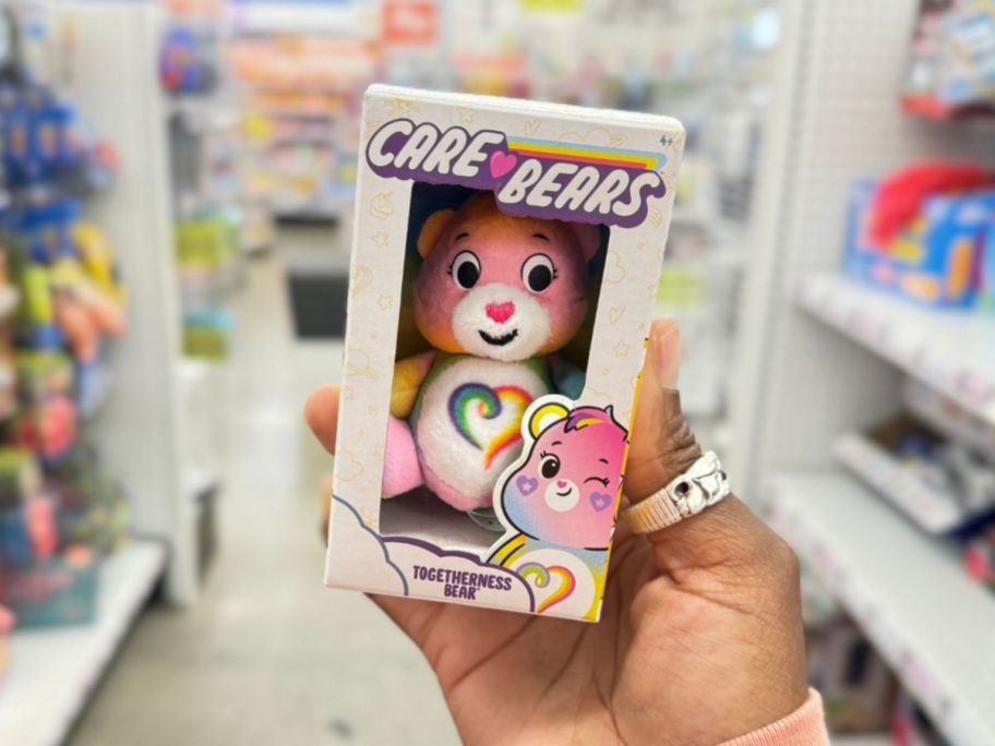 hand holding a micro Care Bear in a box
