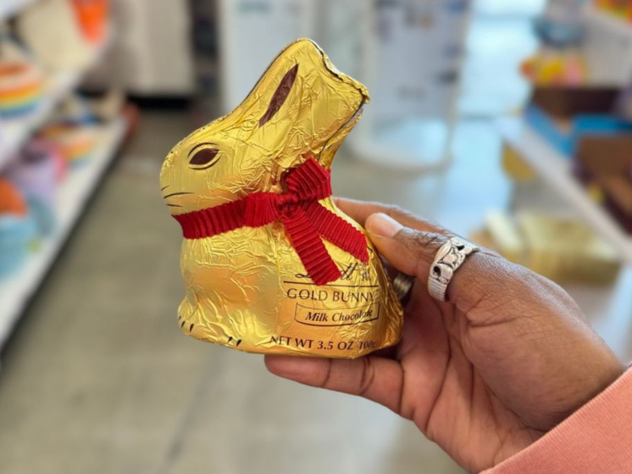 hand holding a gold wrapped chocolate bunny