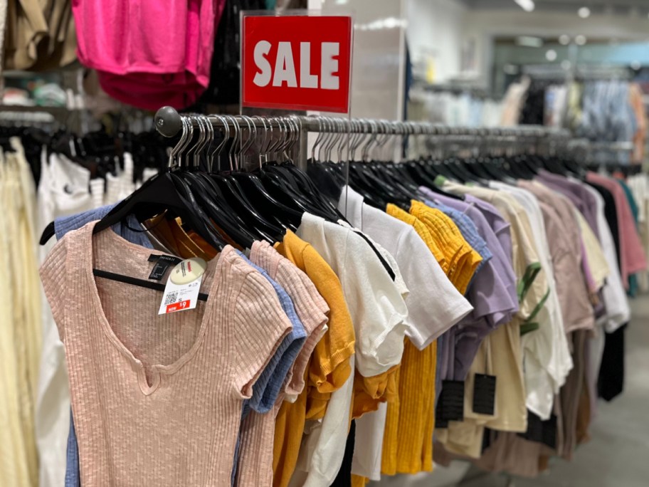 shirts on rack and sale sign in store