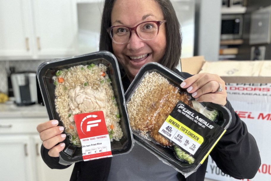 woman holding up two prepared meals
