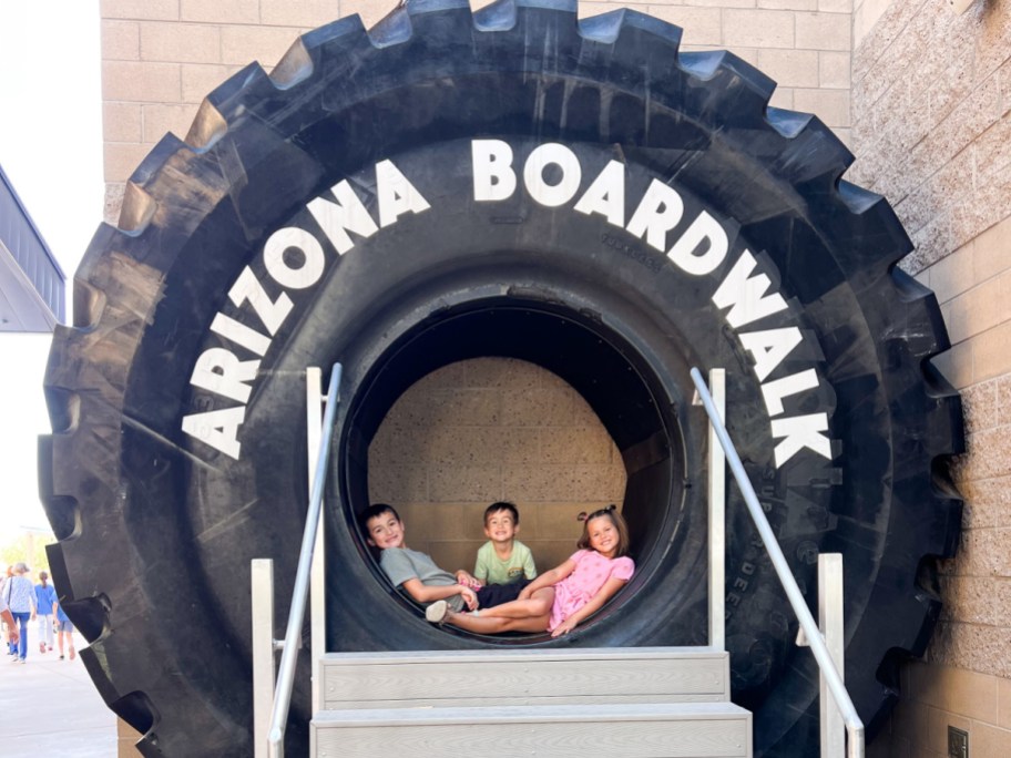 kids sitting in giant tire