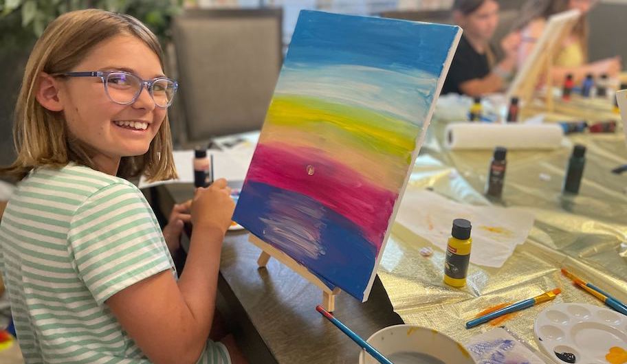 girl painting sunset on canvas 